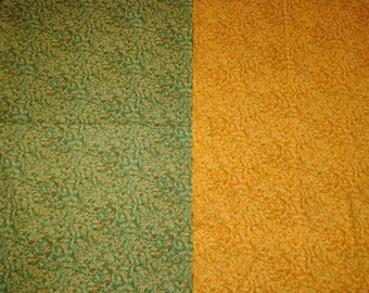 May include: A fabric swatch with a green and yellow pattern. The fabric has a textured, almost bumpy surface.