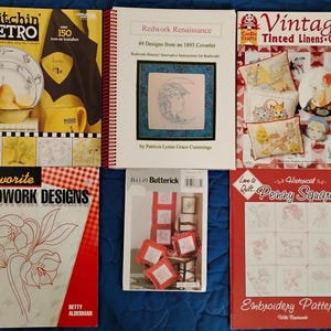 May include: A collection of vintage sewing and quilting books. Titles include "Stitchin' Retro", "Redwork Renaissance", "Vintage Tinted Linens Quilts", "Favorite Redwork Designs", "Butterick", and "Historical Penny Squares". The books feature colorful covers with illustrations and text.