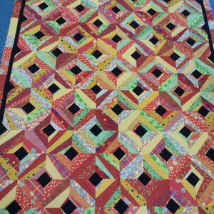 Colorful quilt top design sewn to base fabric 56" x 90" Machine pieced Four blocks create 10" block cotton fabrics 1" w. black centers 2000s