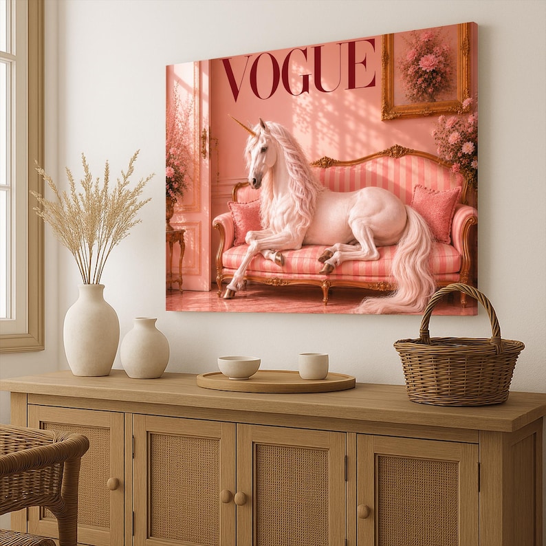 May include: A canvas print featuring a white unicorn reclining on a pink striped sofa. The word "VOGUE" is displayed in large, red letters. The artwork has a soft, romantic aesthetic with a vintage feel.