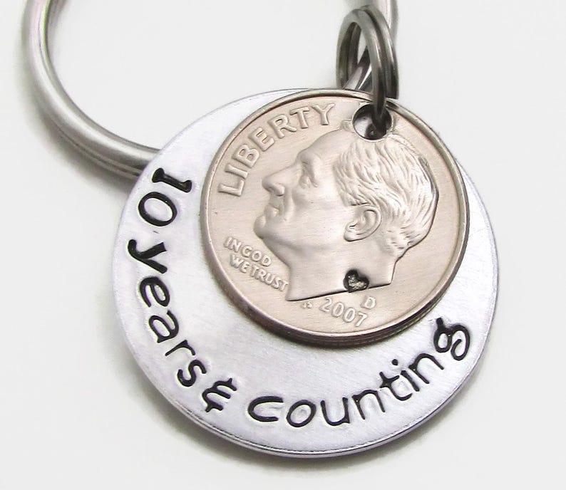 May include: Silver keychain with a silver dime and the text "10 Years Counting" engraved on the front.