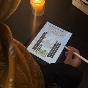 May include: An illuminated candle in a clear glass sits next to a tablet displaying the text "HOW TO FALL IN LOVE WITH ALLAH". A stylus rests on the tablet screen. The scene is set on a dark surface.