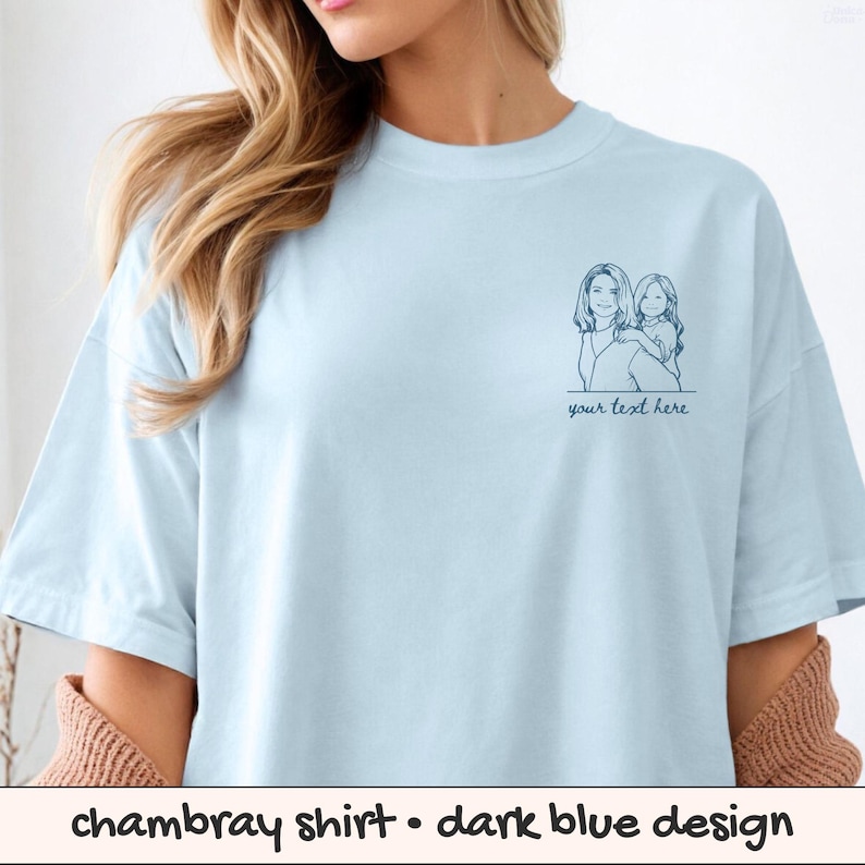 Puede incluir: Camiseta de chambray azul claro con un dise&ntilde;o azul oscuro. La camiseta presenta un dibujo lineal azul oscuro de una mujer y un ni&ntilde;o con el texto "your text here" debajo.