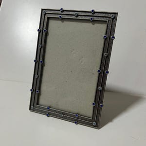 Cornice portafoto Elsa L Inc in peltro con cristalli blu e finitura metallica testurizzata, dimensioni 4x6 pollici.