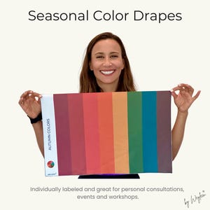 May include: A rectangular fabric drape featuring vertical stripes in various shades of red, orange, yellow, green, and brown. The left side has a white border with the text "AUTUMN COLORS" and a circular colour wheel icon. The brand name "WEYLEEN" is printed below.