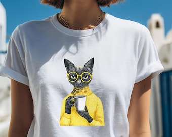 May include: White t-shirt featuring a black cat wearing yellow glasses and a yellow sweater, holding a white mug. The cat illustration has a vintage, artistic style. The shirt is a classic crew neck.