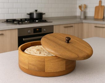 May include: A wooden tortilla warmer with a lid, partially open to reveal a stack of tortillas. The warmer is made of light brown wood and has a round shape. The lid has a small, dark brown knob.