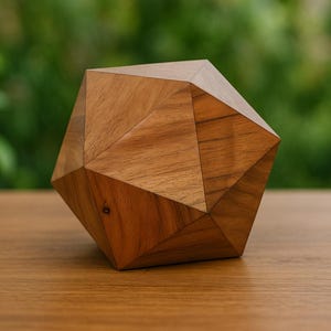 May include: A geometric wooden sculpture with a multifaceted design. The sculpture is made of light brown wood and sits on a wooden surface. The background is a blurred green.