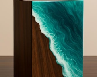May include: A wooden box with a dark brown finish. One side features a turquoise and white resin design depicting ocean waves meeting a sandy shore. The box is rectangular and sits on a wooden surface.