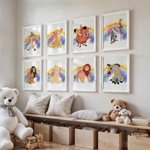Op de afbeelding: Een verzameling van acht ingelijste aquareldrukken met personages uit The Lion King. Elke print toont een ander personage tegen een regenboogachtergrond. De kunstwerken worden tentoongesteld boven een houten bank met opbergdozen, een teddybeer en een grote witte teddybeer.
