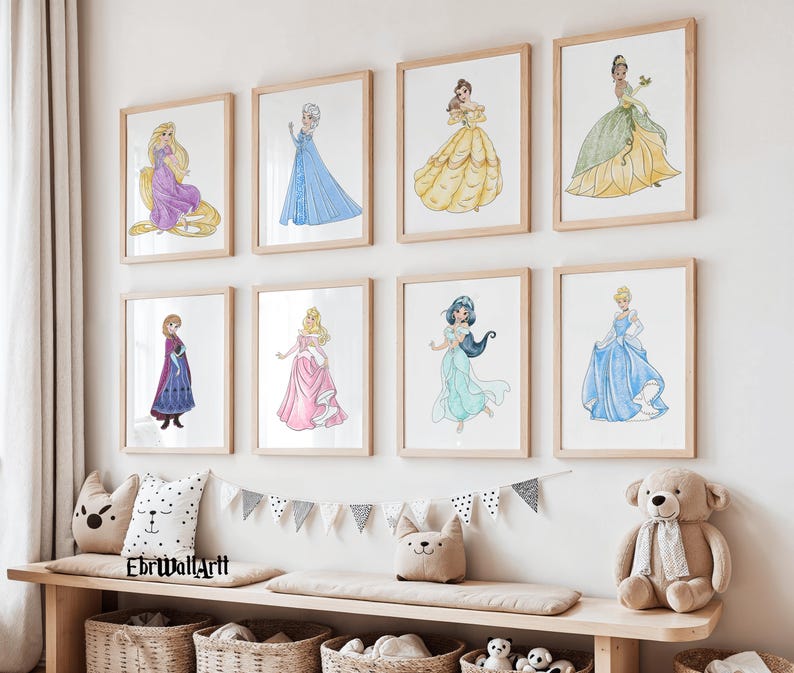 May include: Eight framed watercolor prints of Disney princesses in their iconic gowns. The artwork features Rapunzel, Elsa, Belle, Tiana, Anna, Aurora, Jasmine, and Cinderella. The prints are displayed above a wooden bench with decorative pillows and baskets.
