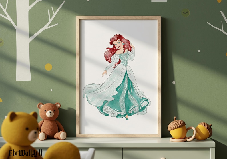 May include: A framed print featuring a watercolor illustration of a princess with long red hair and a flowing teal and white gown. The artwork is displayed in a light wood frame, suitable for a child's room or nursery.