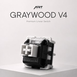 May include: A close-up of a mechanical keyboard switch labeled "GRAYWOOD V4" with the text "Premium Linear Switch". The switch is black and white with a clear top. The brand logo "ART" is at the top.