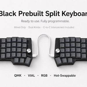 Puede incluir: Un teclado dividido negro preensamblado con teclas gris oscuro, dos perillas plateadas y un cable de interconexión blanco. El texto dice: Black Prebuilt Split Keyboard, Ready to use. Fully programmable. Wired Only, Dual Knobs, C-to-C Interconnect Included, QMK, VIAL, RGB, Hot-Swappable.
