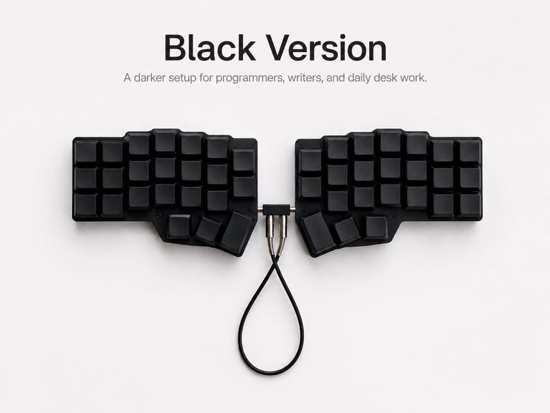 May include: A black split ergonomic keyboard with blank keycaps. The two halves are connected by a central bridge and a black cable loop. Text above reads: Black Version. A darker setup for programmers, writers, and daily desk work.