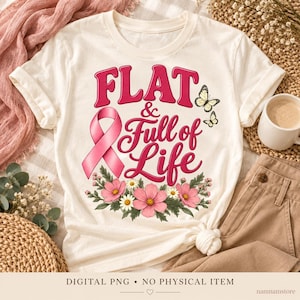 May include: A cream-colored short-sleeve t-shirt featuring a graphic print with the text "FLAT & Full of Life" in pink. The design includes a pink awareness ribbon, two yellow butterflies, and a floral arrangement of pink and white flowers.