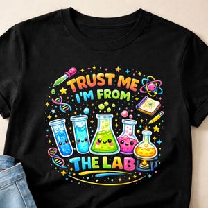 May include: Black t-shirt with a colorful graphic featuring laboratory equipment and the text "TRUST ME I'M FROM THE LAB". The design includes beakers, test tubes, and a DNA strand, with a cartoonish style.