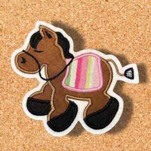 May include: Brown horse applique with a pink and green striped saddle. The horse is standing on its hind legs with its head turned to the side.