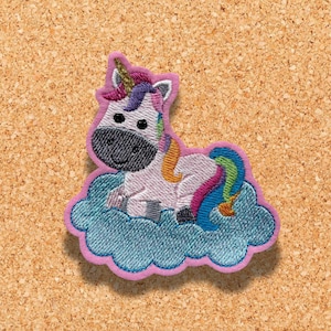 Op de afbeelding: Een wit eenhoorn met een regenboogmanen en staart zit op een blauwe wolk met een roze omtrek. Het eenhoorn heeft een gouden hoorn en zwarte ogen.