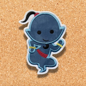 Puede incluir: Parche azul bordado de un genio de Aladdin, con una diadema dorada y una faja roja. El genio sonríe y tiene un cuerpo azul con un contorno blanco.