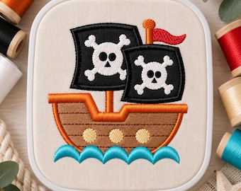 May include: An embroidery design in a white plastic hoop featuring a brown pirate ship with three yellow portholes, sailing on blue waves. The ship has two black sails, each displaying a white skull and crossbones, and a small red flag on top.