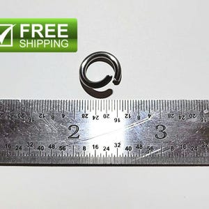 May include: A small, dark metal ring with a gap, positioned above a ruler. The ruler displays inch measurements. The image also includes a green rectangle with the text "FREE SHIPPING" and a checkmark.