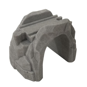 Puede incluir: Un túnel de tren de juguete de plástico gris con un exterior rocoso. El túnel tiene una abertura arqueada y una parte superior plana con ranuras para vías de tren. El juguete está diseñado para parecerse a un túnel de piedra.