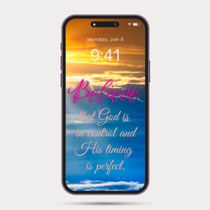 以下が含まれることがあります： 紫色のフレームのスマートフォンは、夕日の壁紙を表示しています。画面には、日付と時刻とともに、「Believe that God is in control and His timing is perfect」という言葉がスクリプトで表示されています。