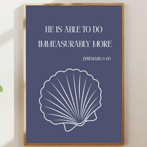 May include: A framed print with a navy blue background and white text that reads "HE IS ABLE TO DO IMMEASURABLY MORE" and "EPHESIANS 3:20". A white seashell graphic is at the bottom.