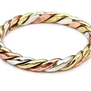 May include: A braided ring featuring three intertwined strands of metal in gold, silver, and rose gold tones. The ring is set against a white background, highlighting its intricate design and color variations. This piece of jewelry is a stylish accessory.