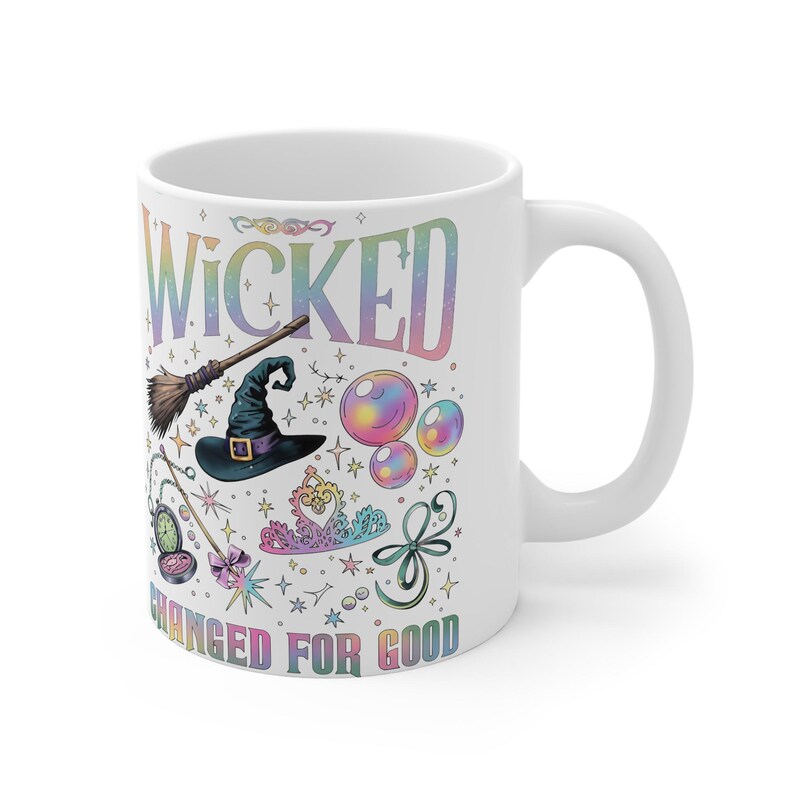 May include: White ceramic mug with a colorful design featuring the word "WICKED" and the phrase "CHANGED FOR GOOD". The design includes a witch hat, broom, bubbles, and other whimsical elements.