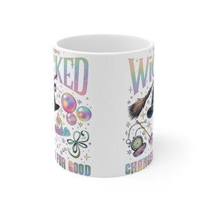 May include: White ceramic mug with the words "Wicked" and "Witch" in a rainbow gradient font. The mug features whimsical illustrations of a witch's hat, bubbles, a broom, and a pocket watch. The text "Changed for Good" is also visible.