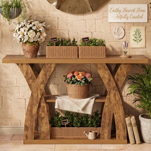May include: A wooden console table with an X-frame base, featuring two shelves. The table holds woven baskets with herbs, a flower-filled vase, a basket of roses, a white cloth, a small watering can, and two books. A sign reads Earthy Harvest Home.