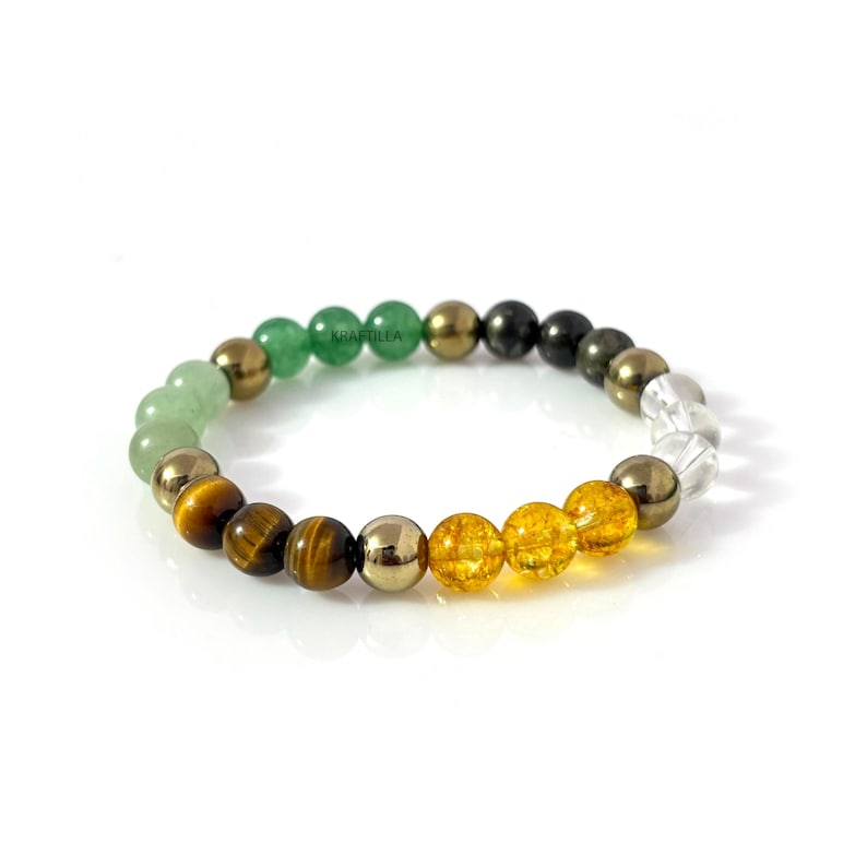 May include: A multi-coloured beaded bracelet with a range of gemstones. The bracelet incorporates green, gold, brown, yellow, and clear beads. The beads are strung on an elastic band. The bracelet is shown against a white backdrop.