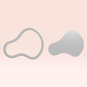 Può includere: Due oggetti astratti grigi a forma di goccia su uno sfondo rosa chiaro. Uno è una forma solida, l'altro è un contorno. Gli oggetti hanno un design liscio e moderno.