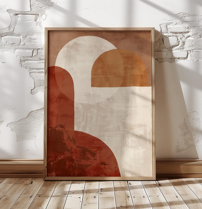 May include: Framed abstract art print with a wooden frame. The artwork uses geometric shapes in rust, beige, and white. The design includes semi-circles and rectangular forms, creating a modern, minimalist aesthetic. The print is displayed against a white brick wall.