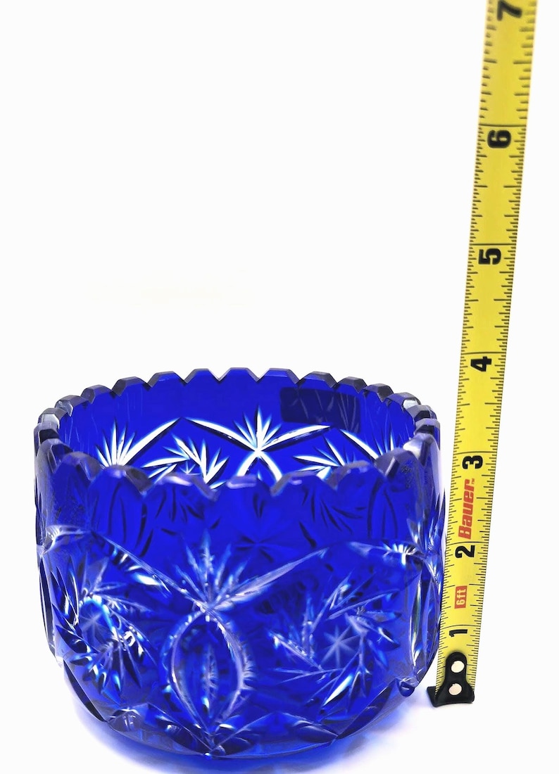 Op de afbeelding: Een levendige kobaltblauwe glazen kom met een sterrenpatroon. De kom heeft een geschulpte rand en meet ongeveer 7.6 cm in diameter. De kom is gemaakt van geslepen glas en staat op een witte achtergrond.