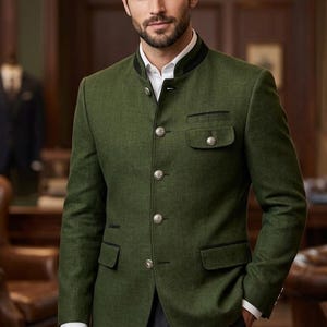 May include: A green jacket with a mandarin collar, black trim, and silver buttons. The jacket has two front pockets and a chest pocket. The person is wearing a white shirt and dark gray pants. The jacket is a traditional style.