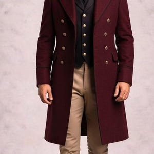 May include: A long burgundy coat with a black velvet collar and double-breasted gold buttons, worn over a black vest with gold buttons, a white collared shirt with a black necktie, tan trousers, and tall dark brown leather riding boots.