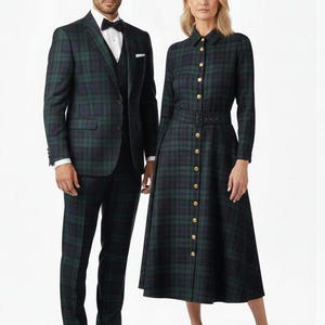 Könnte beinhalten: Ein Mann in einem dunkelgrünen und blauen Tartan-Anzug mit weißem Hemd und schwarzer Fliege steht neben einer Frau in einem passenden Tartan-Kleid. Das Kleid hat goldene Knöpfe und einen Gürtel. Formelle Kleidung.