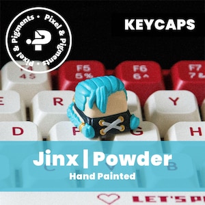 May include: A hand-painted keycap featuring a character with blue hair and a black outfit, sitting on a keyboard. The keycap is labeled "Jinx | Powder" and the word "KEYCAPS" is displayed above. The Pixel & Pigments logo is in the upper left corner.