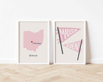 Può includere: Due stampe artistiche incorniciate. La stampa a sinistra presenta un contorno rosa dell'Ohio con "Columbus" e un cuore. La stampa a destra mostra due gagliardetti rosa con "MADISON" e "EDEN" in testo bianco. Entrambe le stampe hanno un bordo bianco.