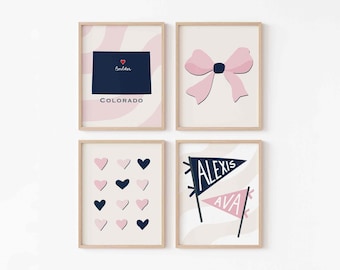 Può includere: Quattro stampe artistiche incorniciate con cornici in legno chiaro. Le stampe presentano una mappa dello stato del Colorado, un fiocco rosa, cuori rosa e blu navy e bandierine con nomi. La tavolozza dei colori include rosa, blu navy e bianco.