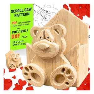 Puede incluir: Un patrón de sierra de calar en forma de oso de madera, con el texto "SCROLL SAW PATTERN" y "PDF/SVG/DXF FILES". El oso tiene una espalda en forma de casa y patas en forma de pata. También es visible un modelo de oso más pequeño. Recortes rojos en forma de corazón están dispersos.