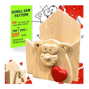 May include: A wooden scroll saw pattern for a decorative wall-mounted holder, featuring a carved animal face and a red heart. The design includes the text "SCROLL SAW PATTERN" and "PDF/SVG/DXF FILES".