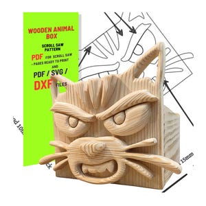 May include: A wooden animal box with a carved cat face design. The box is made of light-colored wood and features a detailed, expressive face with large eyes, a nose, and whiskers. The box is approximately 15mm thick. A green rectangle with text that says "WOODEN ANIMAL BOX" is on the left.