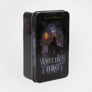 May include: A rectangular metal tin featuring the text "Witches Tarot" and the name "Ellen Dugan." The artwork depicts a woman holding a torch in a forest setting, with a dark, mystical aesthetic.