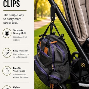 Peut inclure: Des clips de poussette pour transporter plus facilement. L'image montre une poussette noire avec un sac à langer gris et violet attaché. Le texte sur l'image dit "Secure & Strong Hold", "Easy to Attach", et "Free Up Your Hands".