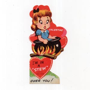 May include: A vintage Valentine card featuring a cartoon character with blonde hair and a blue dress sitting in a black pot over a fire. The card includes the text VALENTINE, I'M IN A "STEW" OVER YOU!, and Made in U.S.A. on a red heart shape.