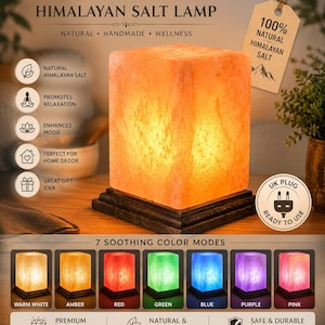 Könnte beinhalten: Himalaya-Salzlampe mit warmem orangefarbenem Leuchten, auf einem dunklen Holzsockel stehend. Die würfelförmige Lampe trägt den Text "Himalayan Salt Lamp". Zusätzlicher Text beinhaltet "Natural, Handmade, Wellness" und "7 Soothing Color Modes."